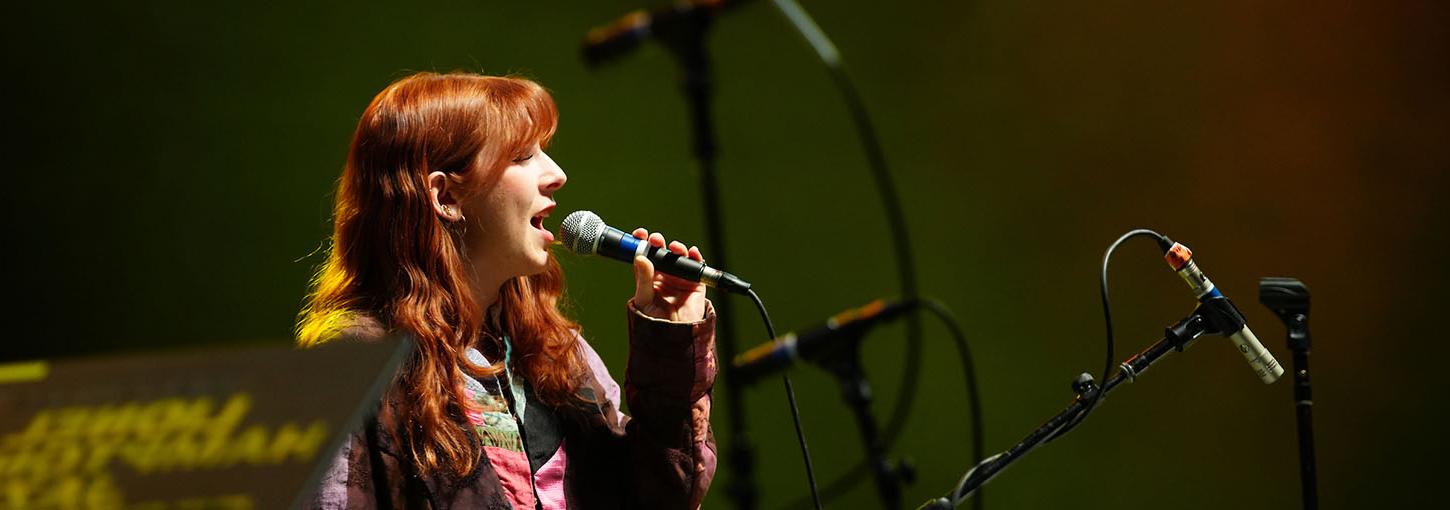 Woman singing on stage with microphone